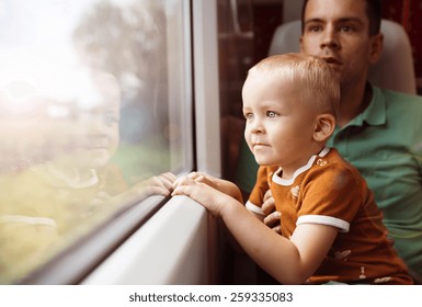 Father with son in his lap traveling in train.