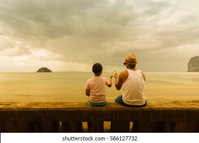 Father And Son   Holding Ice Cream Or Family Asian Eating Ice Cream On The Beach In The Evening.