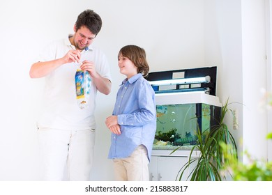 Father And Son Holding A Plastic Bag With A New Fish They Got In A Zoo Store Ready To Put It Into A Home Aquarium