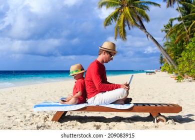 Father And Son With Laptop On Beach Vacation