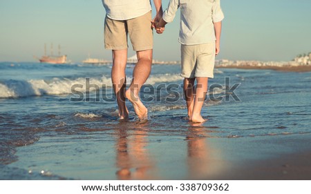 Father and son legs on the sea surfline close up image