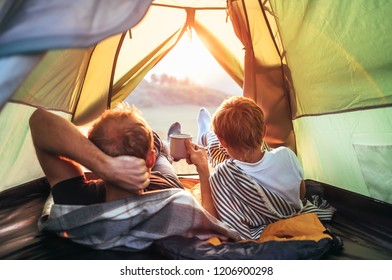 Father and son lie together in touristic tent and enjoy with sun - Powered by Shutterstock