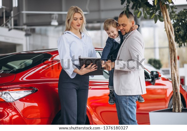 Father with\
son looking at a car in a car\
showroom