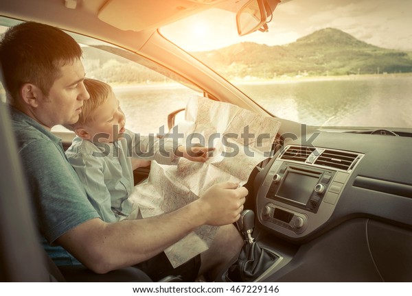Father and son looking on\
map in car
