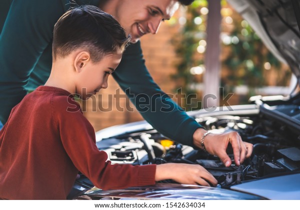 The father and\
son looking under the car\
hood