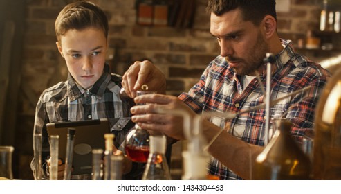 Father And Son Are Making Chemistry Experiments While Checking A Tablet Computer In A Garage At Home.