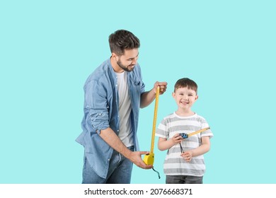 Father and son with measuring tapes on color background - Powered by Shutterstock