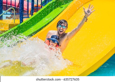 Father And Son On A Water Slide In The Water Park.