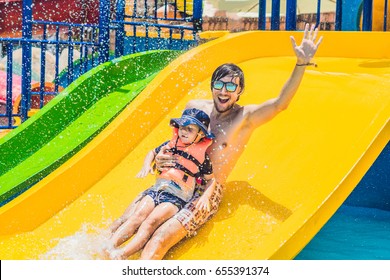 Father and son on a water slide in the water park. - Powered by Shutterstock