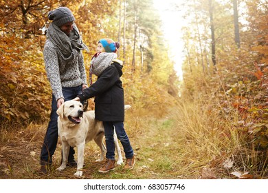Father and son patting dogs head  - Shutterstock ID 683057746