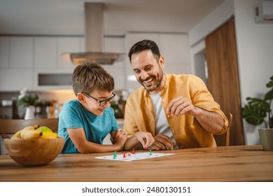 Father and son play board game have fun together at home - Powered by Shutterstock