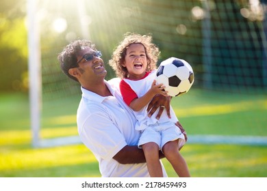 Father And Son Play Football. Dad And Little Boy Play Soccer. Young Active Family Enjoy Sunny Summer Day Outdoor. Healthy Sport For Kids. Football Game Club.