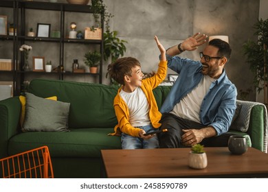 Father and son play video games on a mobile phone and enjoy at home - Powered by Shutterstock