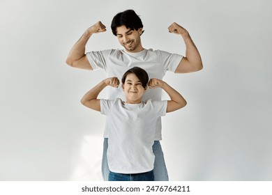 A father and son playfully flex their muscles, capturing a tender moment of bonding and shared strength. - Powered by Shutterstock