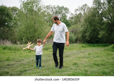 Father And Son Playing In Aviator. Superman Dad And Son Having Fun. Imagination And Dreams Of Being A Pilot. Child Pilot With Airplane On Dads Back. Travel And Vacation In Summer. Freedom