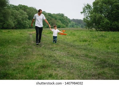 Father And Son Playing In Aviator. Superman Dad And Son Having Fun. Imagination And Dreams Of Being A Pilot. Child Pilot With Airplane On Dads Back. Travel And Vacation In Summer. Freedom