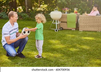 Father and son playing ball in garden