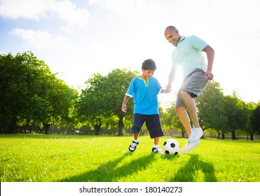 Father And Son Playing Ball In The Park