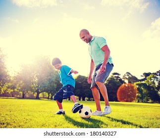 Father And Son Playing Ball In The Park