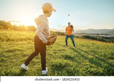 Father and son playing in baseball. Playful Man teaching Boy baseballs exercise outdoors in sunny day at public park. Family sports weekend. Father's day.