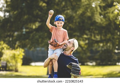 A Father And Son Playing Baseball In Sunny Day At Public Park