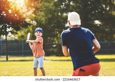 A Father And Son Playing Baseball In Sunny Day At Public Park