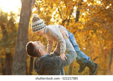 Father and son playing in beautiful autumn park