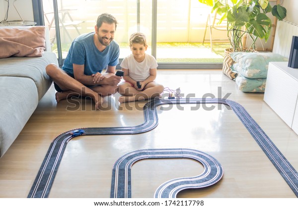 Father and son playing\
car races at home