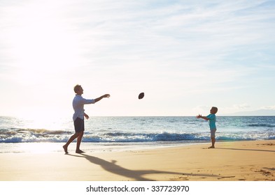 Father And Son Playing Catch Throwing Football On The Beach At Sunset