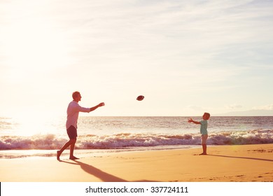 Father And Son Playing Catch Throwing Football On The Beach At Sunset