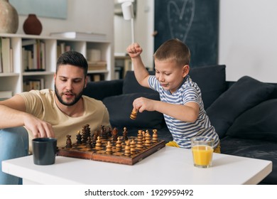 father and son playing chess in living room - Shutterstock ID 1929959492