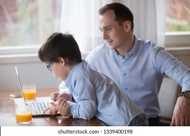 Father And Son Playing Computer Game On Weekend At Home. Family Leisure Time, Gadget Addiction Concept. Smiling Husband Sitting Work On Laptop, Kid In Glasses Look At Monitor, Poor Eyesight Problem