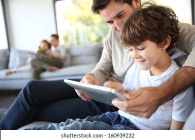 Father and son playing with digital tablet