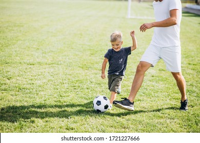Father with son playing football at the field