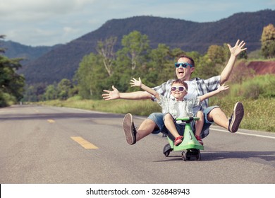 Father and son playing  on the road at the day time.  Concept of friendly family.