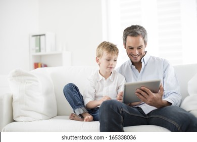 Father And Son Playing On A Tablet