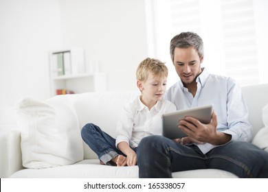 Father And Son Playing On A Tablet