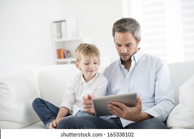 Father And Son Playing On A Tablet