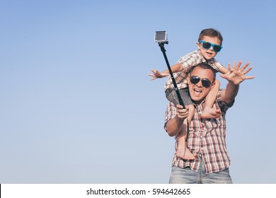 Father and son playing in the park  at the day time. Concept of friendly family. Picture made on the background of blue sky. - Powered by Shutterstock