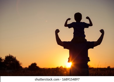 Father and son playing in the park at the sunset time. People having fun on the field. Concept of friendly family and of summer vacation. - Shutterstock ID 1689154897