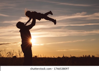 Father and son playing in the park at the sunset time. People having fun on the field. Concept of friendly family and of summer vacation. - Shutterstock ID 1746538097