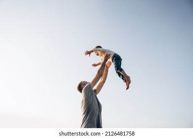 Father and son playing in the park at the sunset time. Family, trust, protecting, care, parenting, summer vacation concept
