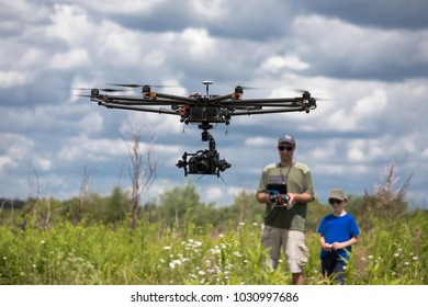 father and son  playing with RC quadrocopter , dron 
