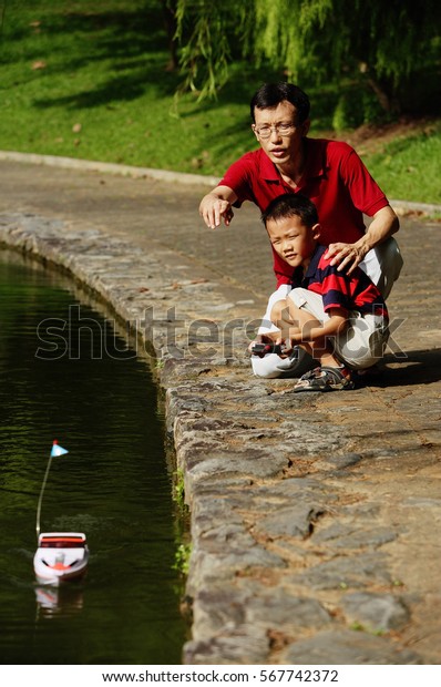 Father and son
playing with remote control
boat