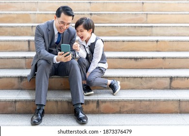 Father And Son Playing  Smart Phone Together On Business District Urban, Dad And Son Happy Asian Family Concept