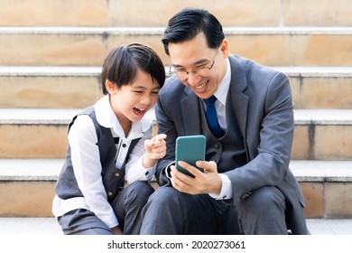 Father And Son Playing  Smart Phone Together On Business District Urban, Dad And Son Happy Asian Family Concept