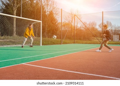 Father And Son Playing Soccer Ball On Playground, Dad Teaches Son To Play On Football Field, Family Weekend Activities.