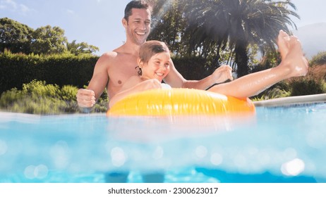 Father and son playing in swimming pool - Powered by Shutterstock