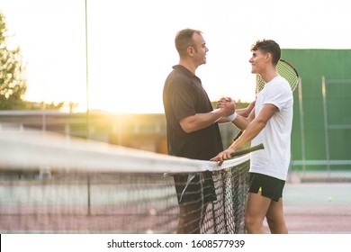 Father and Son Playing Tennis One to One. Family Doing Sport Together . Father Giving a Hug to His Son After Playing Tennis. Family Concept. - Powered by Shutterstock