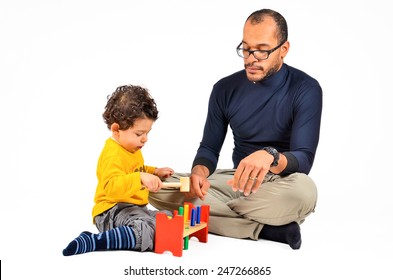 Father And Son Are Playing Together As Part Of The Didactic Autism Children Therapy. A Therapist Is Working With Little Child. Didactic Therapeutic Toys For Autism.  